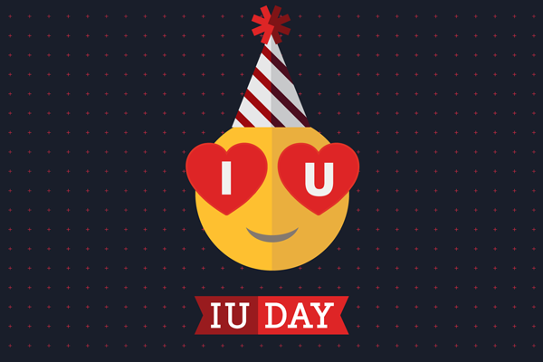 A smiley face with a party hat and ‘IU’ in hearts over its eyes. A banner below says ‘IU Day.’