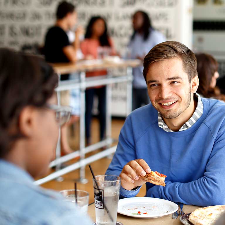 Students dining at a pizza restaurant on Mass Ave